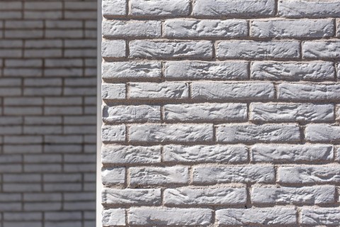 Projectbouw in witte gevelsteen met witte terugliggende voeg