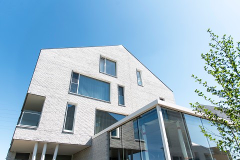 Projectbouw in witte gevelsteen met witte terugliggende voeg