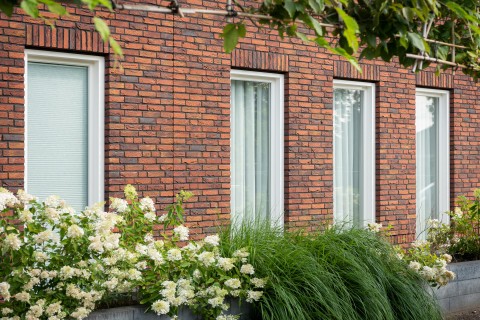 Woning in rode genuanceerde gevelsteen gevoegd